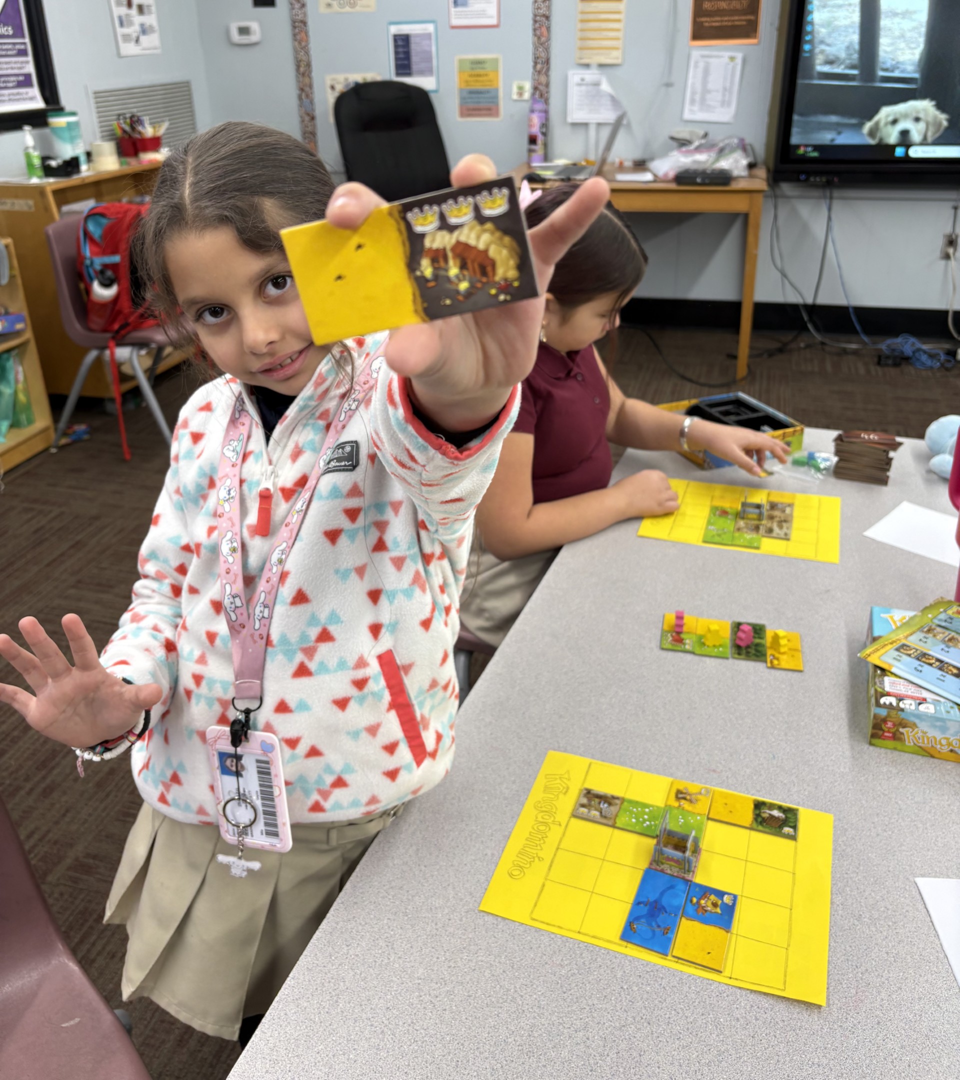 Elementary school student or students shown playing a board game called Kingdominoes.