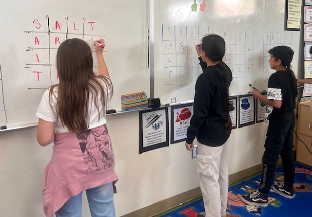This picture shows students participating in a  word activity as part of our Olympics of the Mind unit, engaging with one of Gardner’s multiple intelligences.