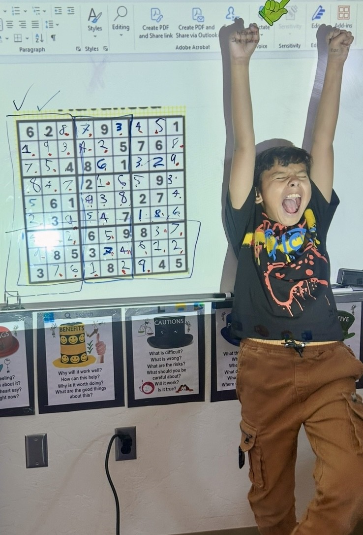 This picture shows a student participating in a Sudoku activity as part of our Olympics of the Mind unit, engaging with one of Gardner’s multiple intelligences.
