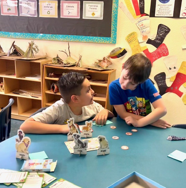 This picture shows students participating in a logic-based game, Dog Crimes, as part of our Olympics of the Mind unit, engaging with one of Gardner’s multiple intelligences.