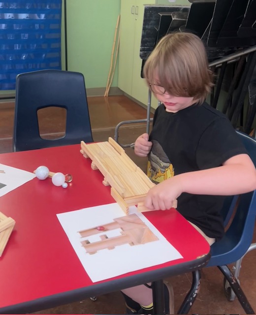 This picture shows a student  participating in a construction activity as part of our Olympics of the Mind unit, engaging with one of Gardner’s multiple intelligences.