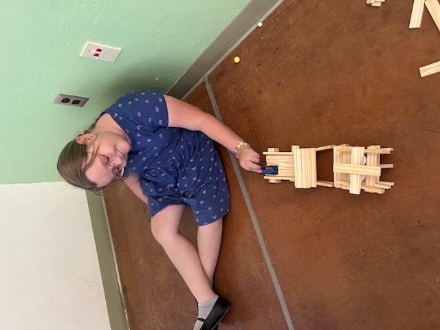 This picture shows a student participating in a construction activity as part of our Olympics of the Mind unit, engaging with one of Gardner’s multiple intelligences.