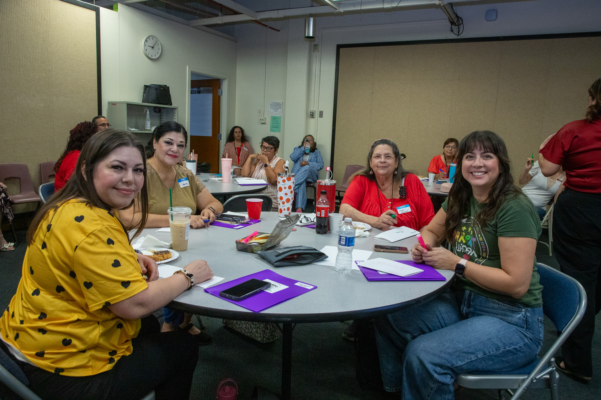 A group of women smile while sitting around a table