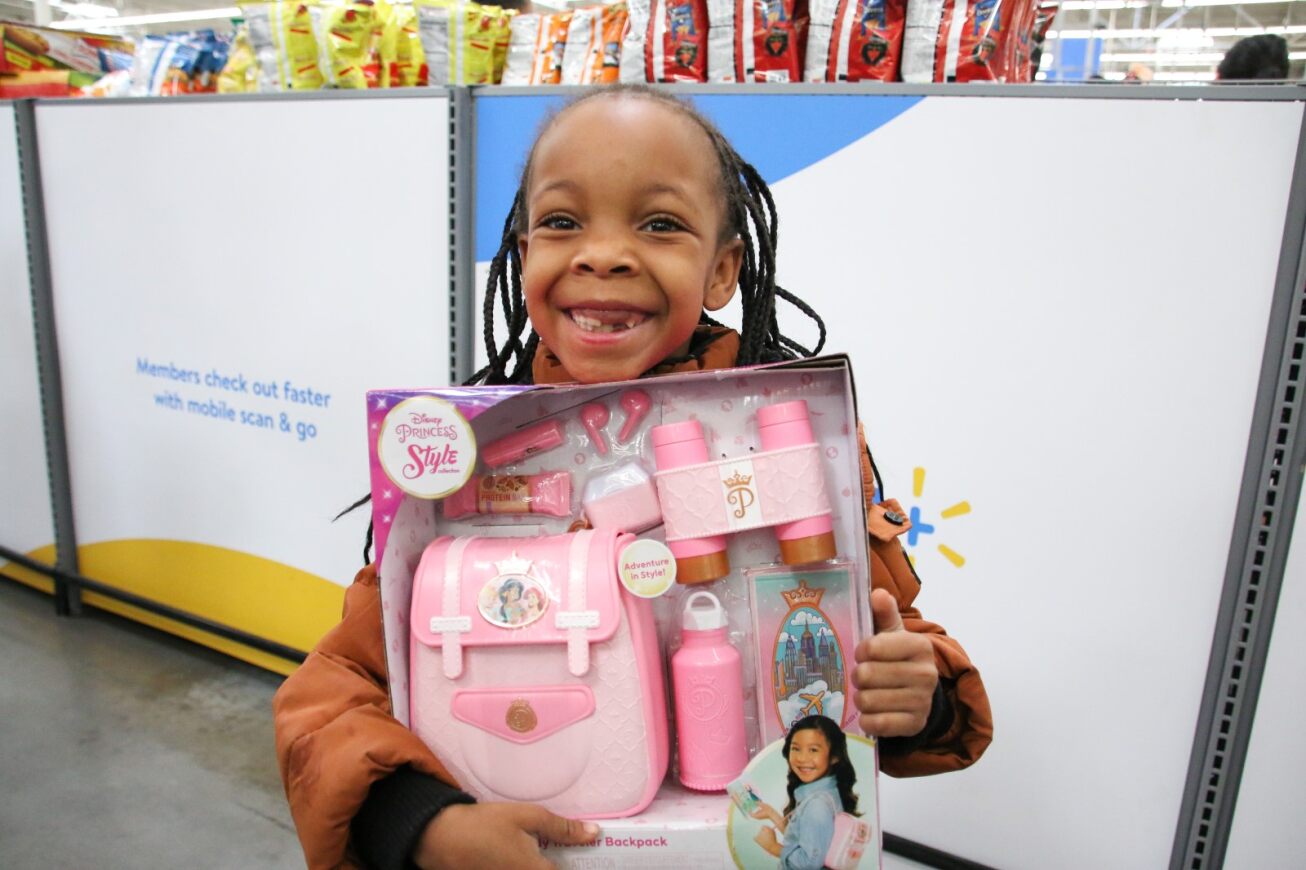A girl smiles with her Disney Princess backpack set.