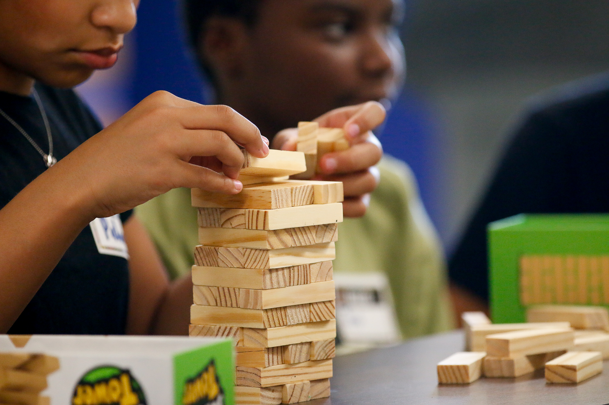 A student stacks Jenga bricks