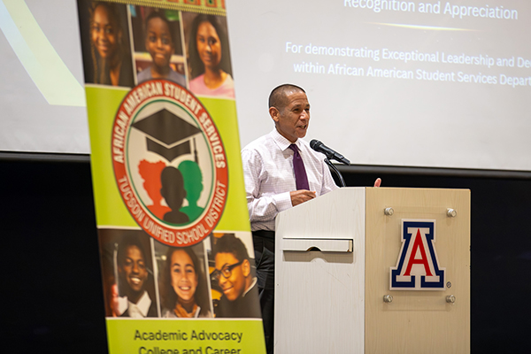 A man stands at the podium addressing the crowd