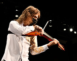 Mark Woods plays violin while leading the TUSD rock orchestra