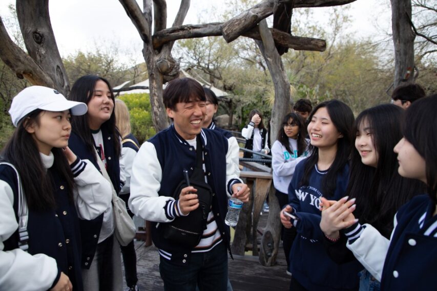 A group of Korean students and their advisor laugh together at the Desert Museum