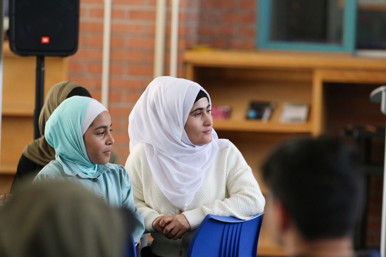 Refugee students listen to a presentation