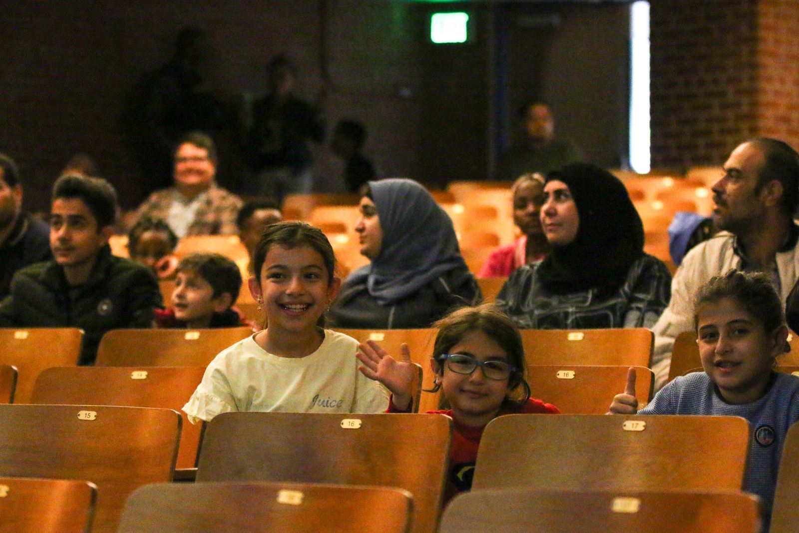 Refugee students smile in the auditorium