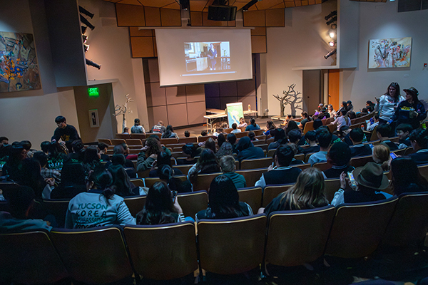 Students watch a presentation in an auditorium