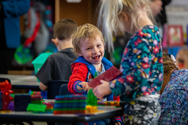 A boy and girl play together with colorful blocks