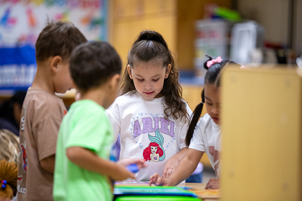 A group of little kids play together at a table