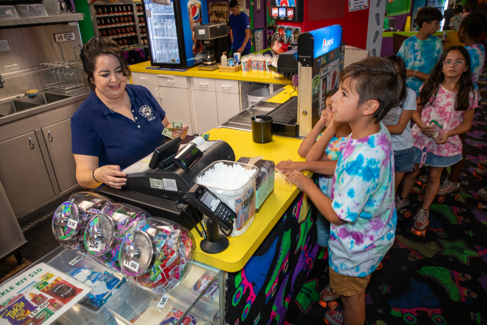 A cashier rings up a young boy