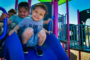 Children on top of a slide.