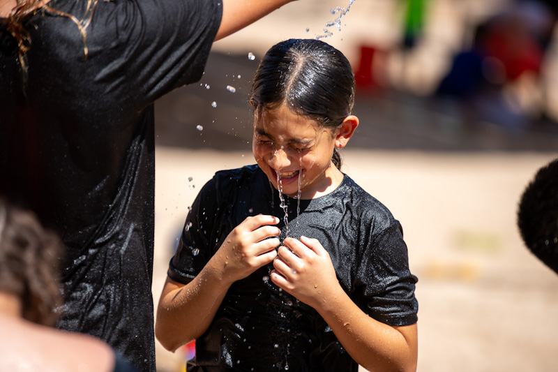 A girl laughs as she gets splashed with water