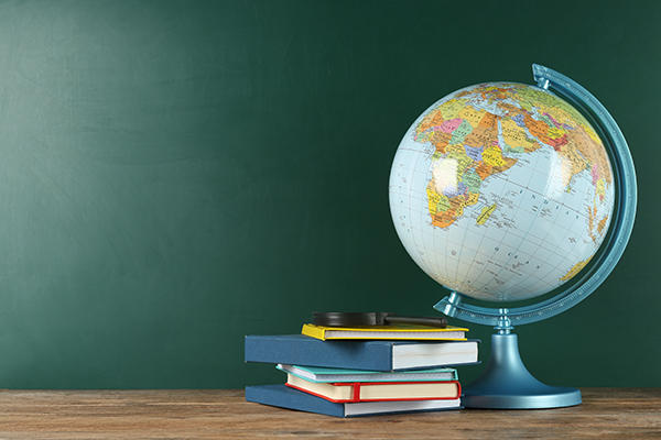 A child's hands grasp a globe