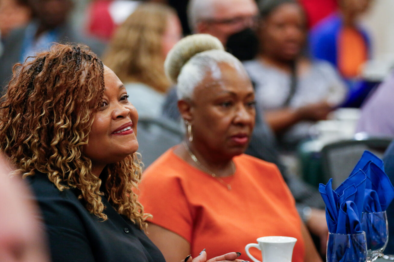Two women watch the EDI Address