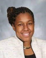image of Kinasha Brown, assistant superintendent of EDI, a black woman with hair in updo, white jacket, and shiny necklace