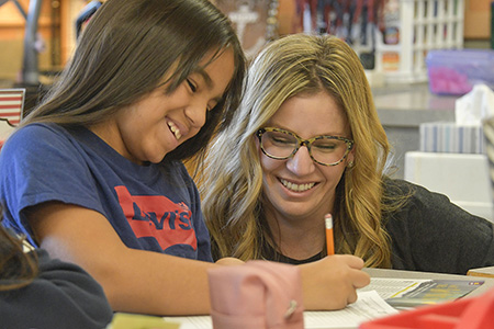 Student and teacher learning on computer.