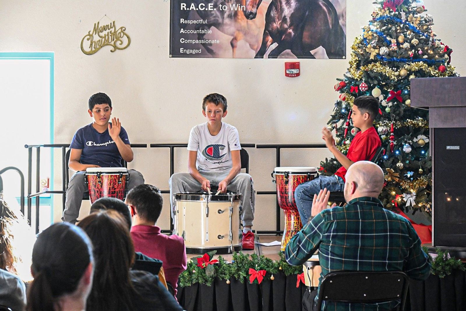 Three boys play drums during the holiday concert.