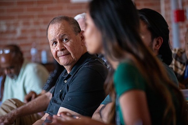 Closeup of two men and a woman listening to a presentation