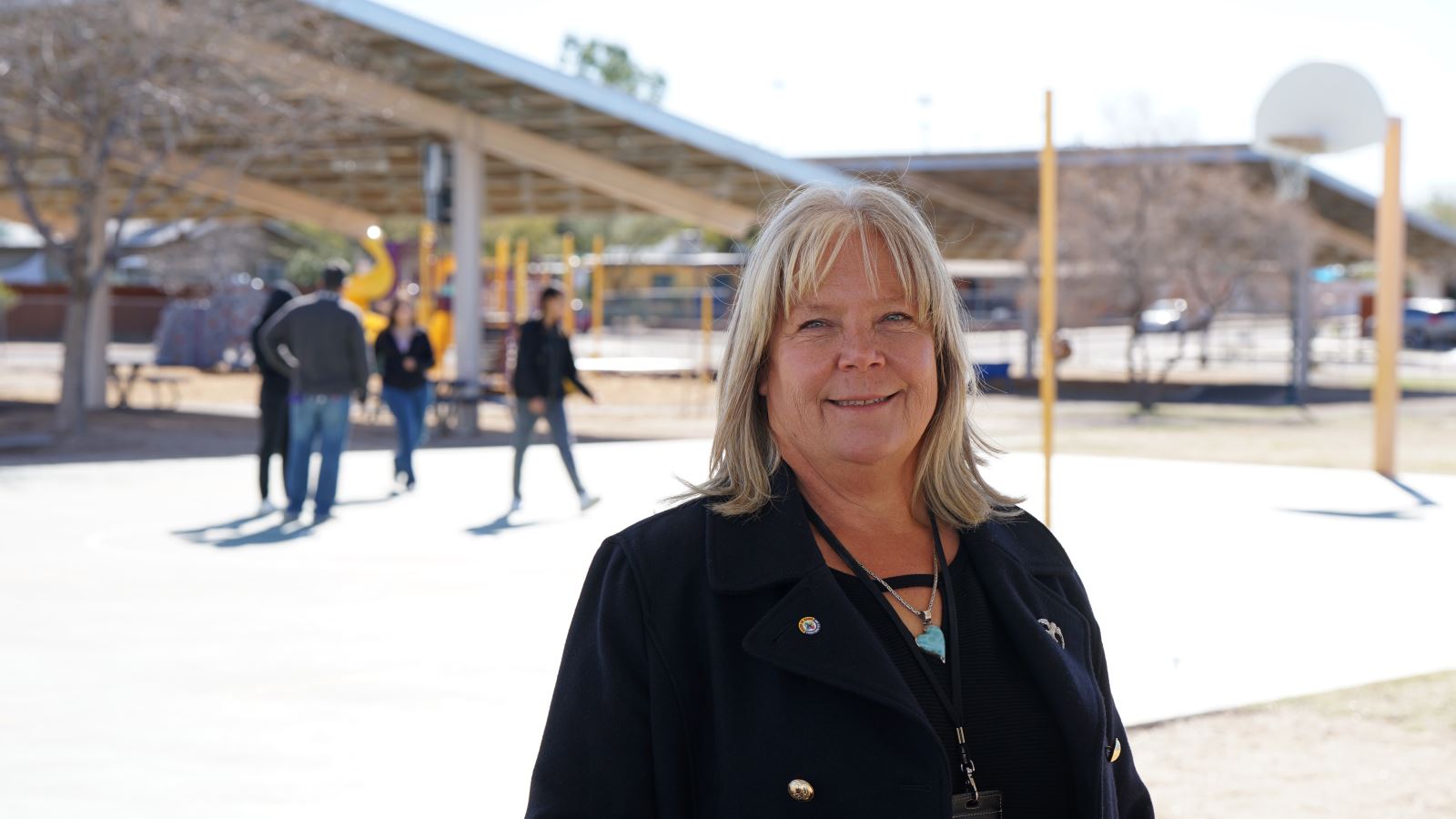 Tina Cook, TUSD's energy project manager, smiles in front of some solar parking structures.