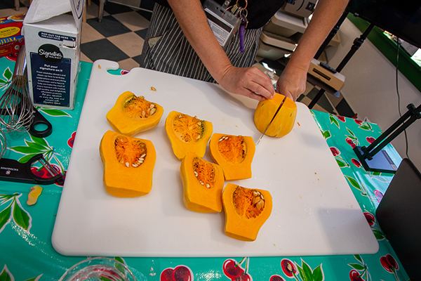 A student cuts up a butternut squash