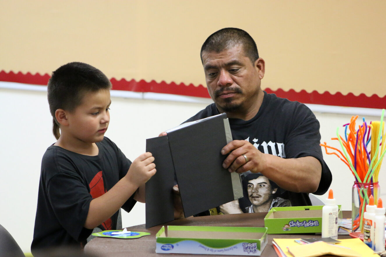 A son and dad work on putting together a book at the Family Mixer.