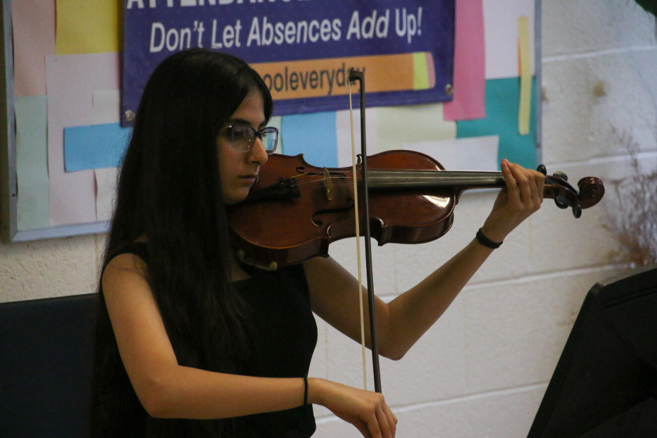 A girl plays the violin at the Family Mixer.