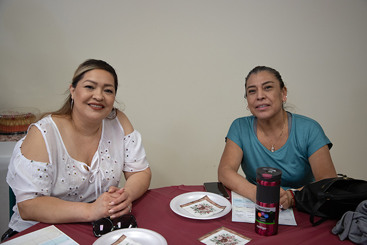 Two women smile at a table