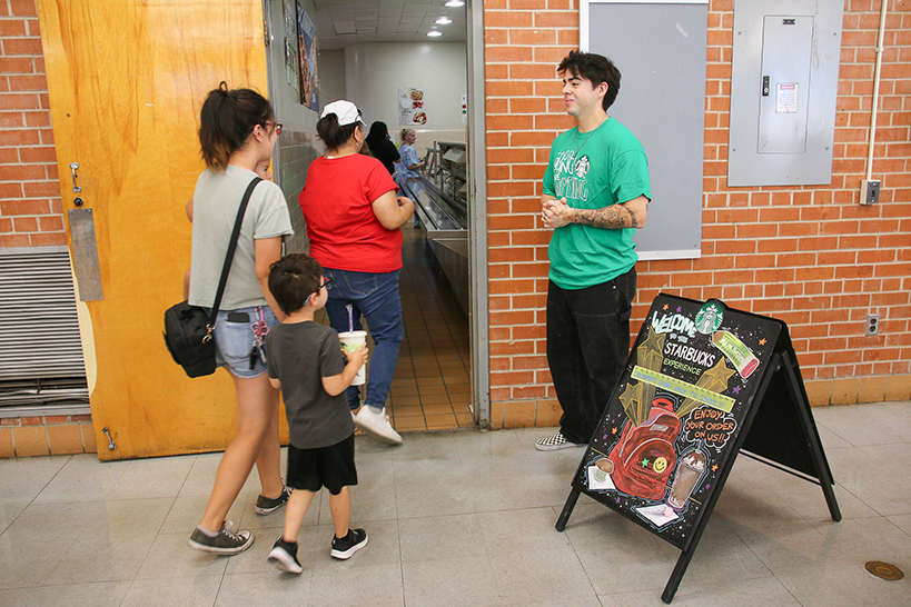 A family is welcomed into the Starbucks Experience in the cafeteria