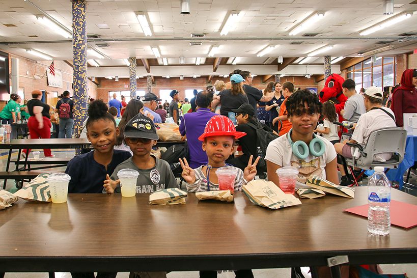 Four students smile at a cafeteria table with their Starbucks goodies