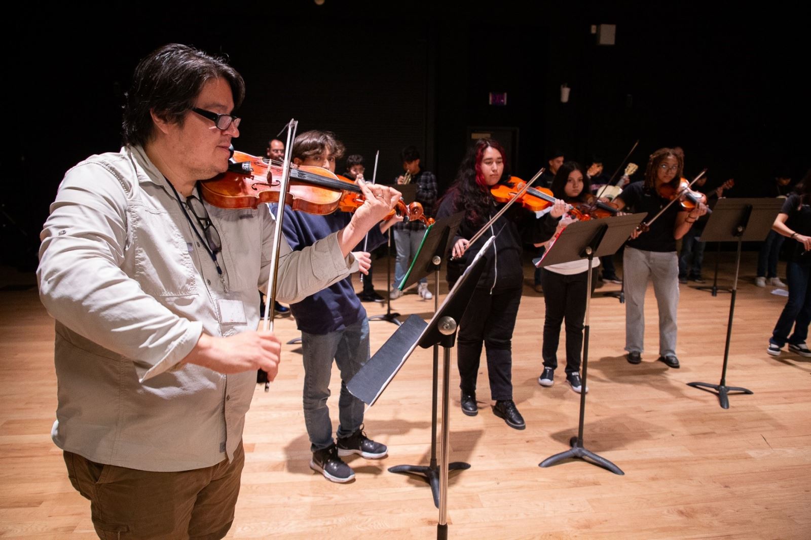 A teacher leads mariachi students on the violin