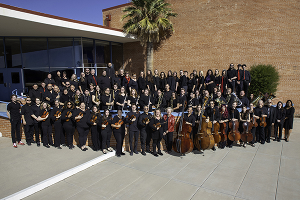 Group photo of musicians outside a school