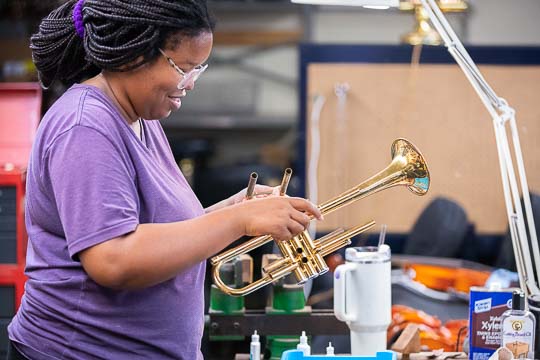 Staff at the center fixes a trumpet for use by one of the students.