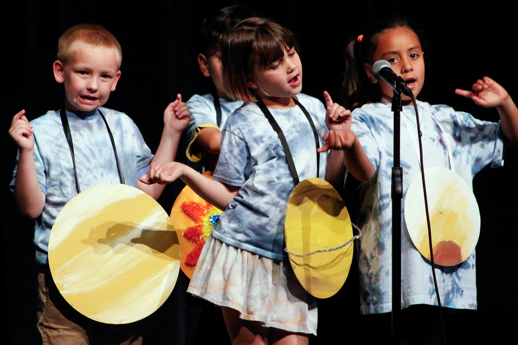 Teacher excitedly performs in front a classroom of first graders.