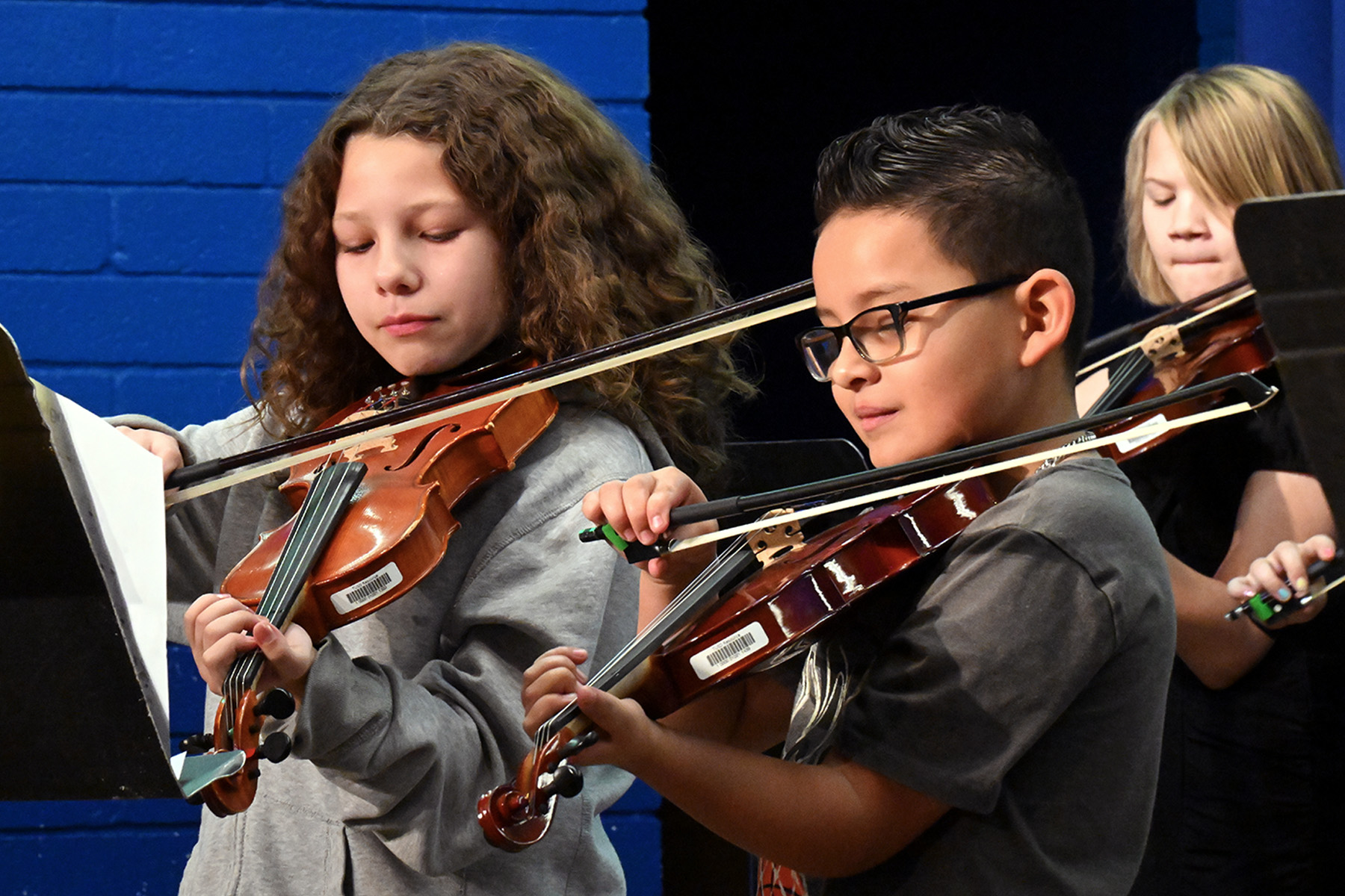 Students play violins.