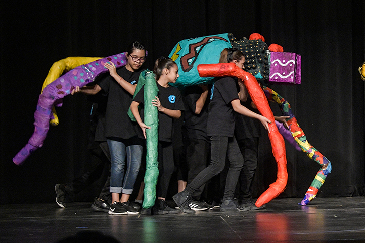 Students paint with vibrant colors.