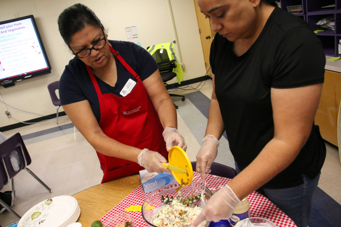 Two women make a healthy dish during Bonillas' nutrition class.