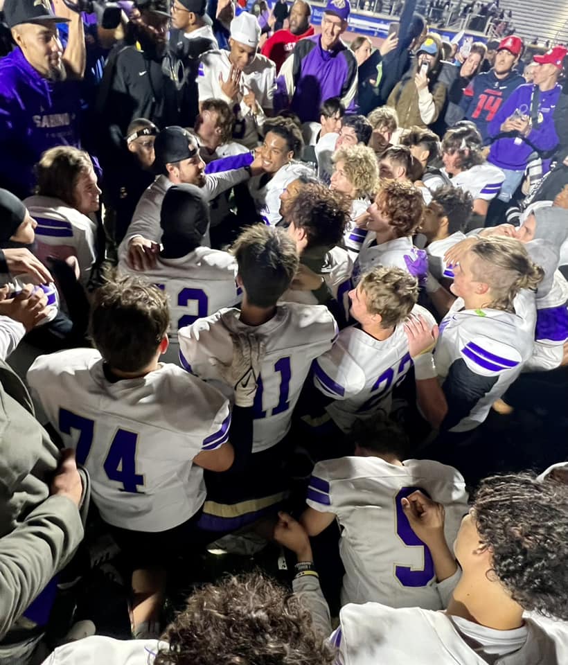 The Sabino football team huddles after winning the game.