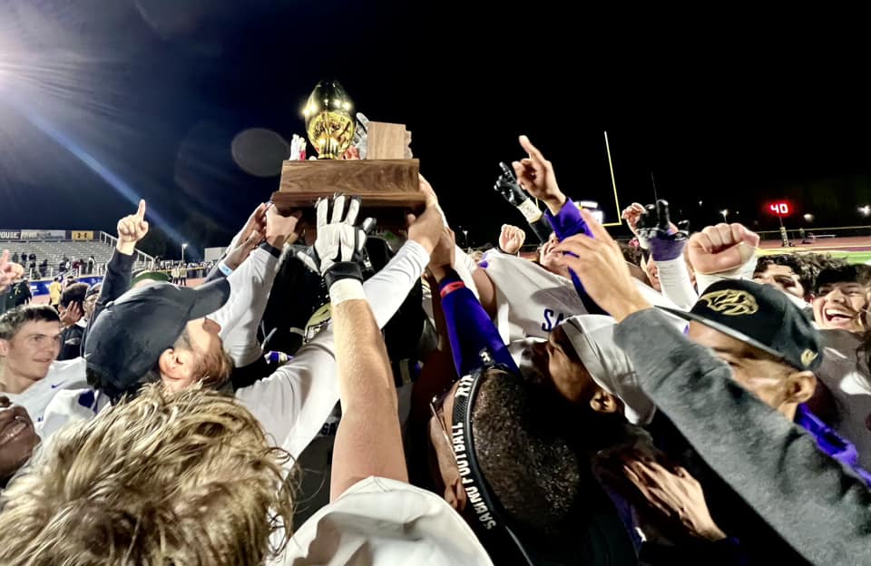 The Sabino football team holds up their trophy.