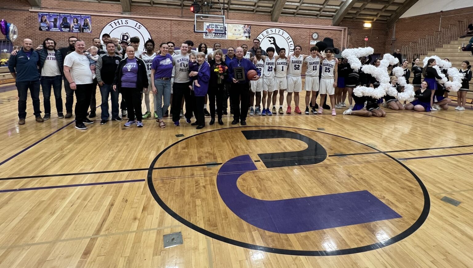 The Ranger athletics staff, RUHS basketball team and cheerleaders pose for a photo with Coach Utter