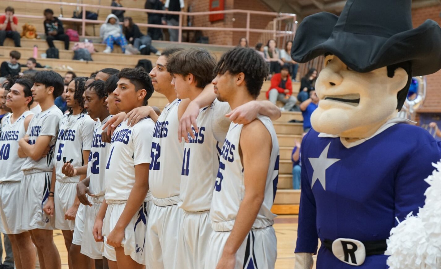 The RUHS team stands on the sidelines with the Rangers mascot