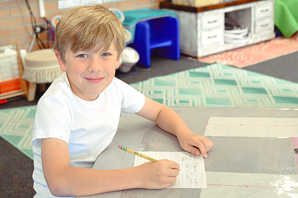 Young student writing at desk.