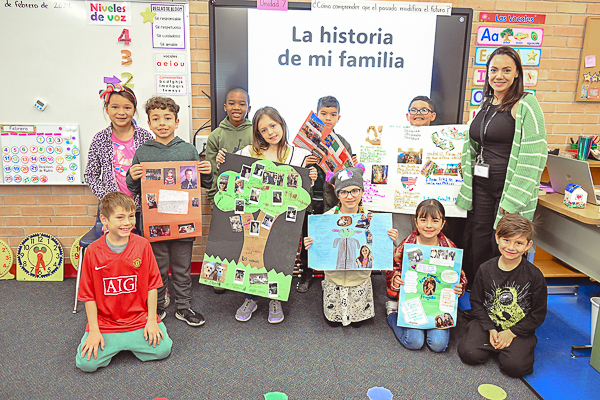 Group of young student holding projects for La historia de mi familia.