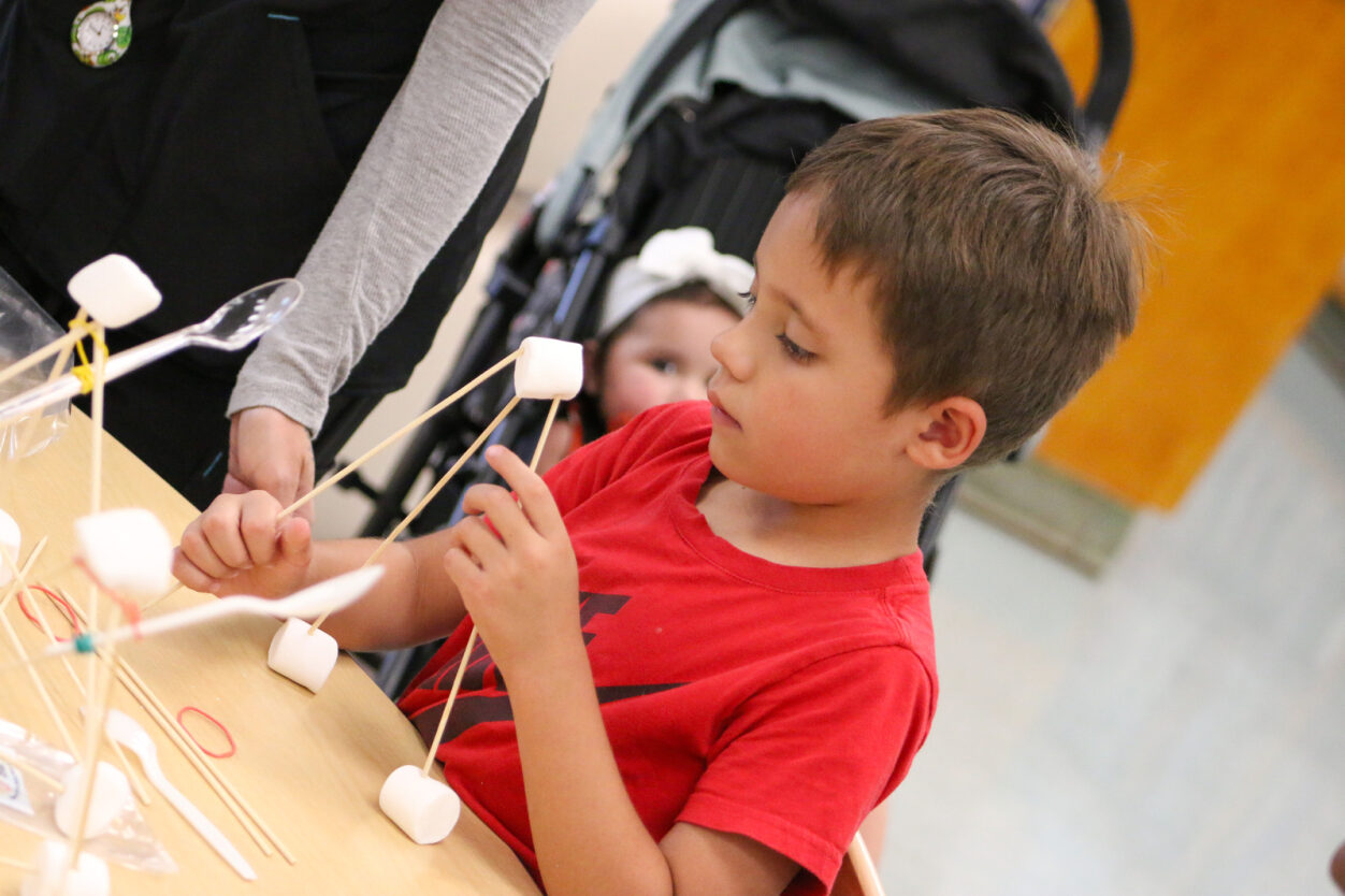 A boy makes a marshmallow catapult.