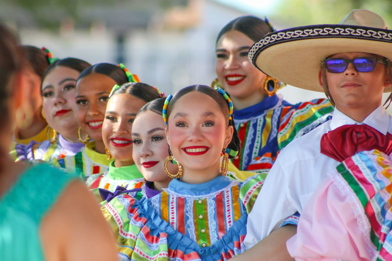 Pueblo High School students smile in traditional clothes during the Mes de la Cultura Opening Ceremony