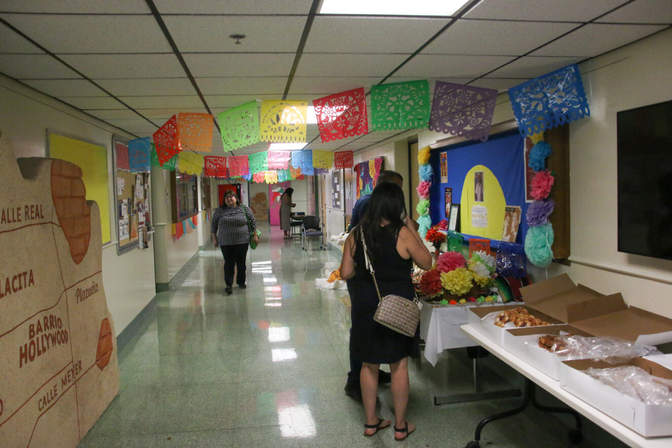 A hallway is decorated with papel picado and Mexican artwork.