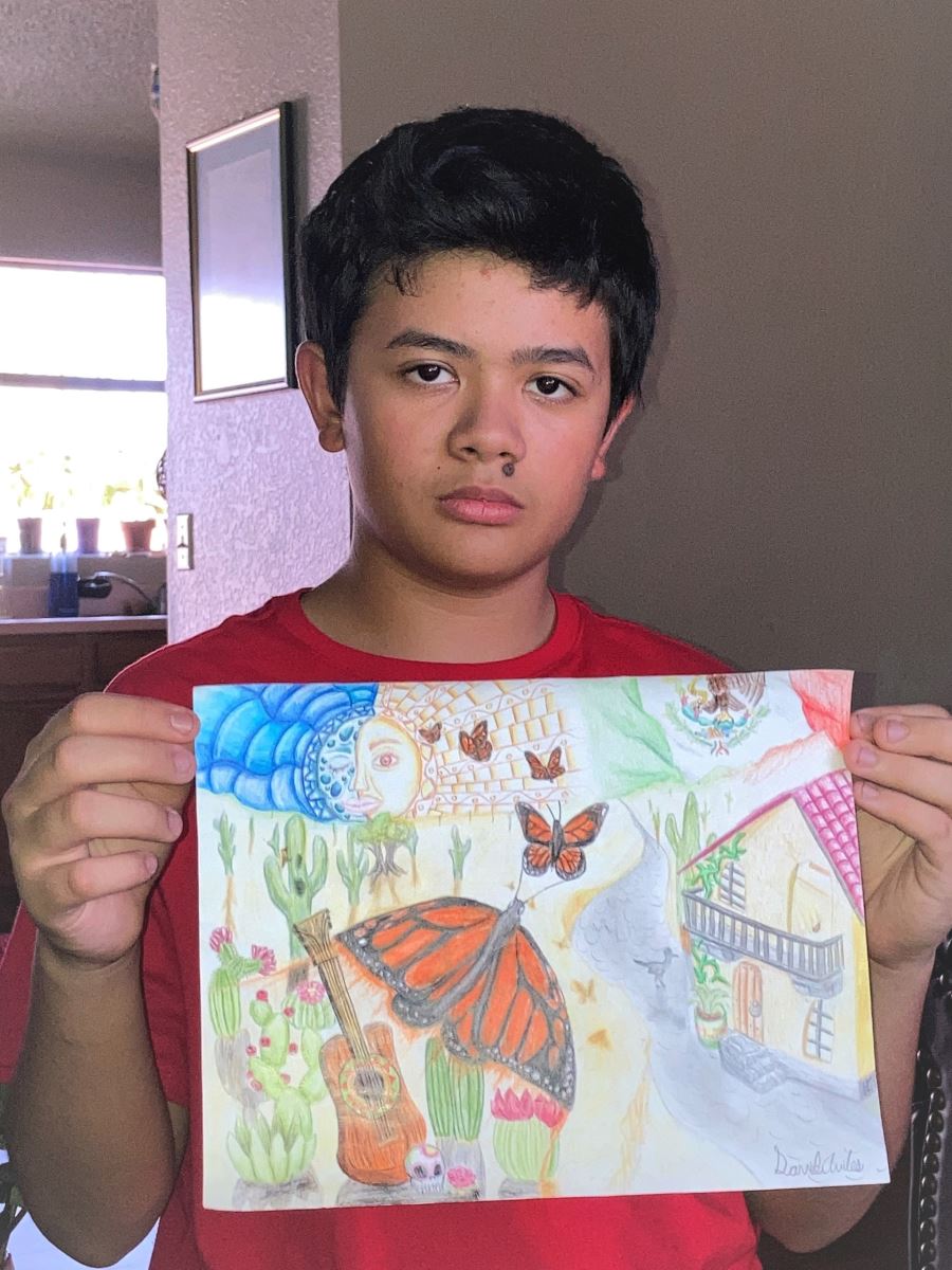 The grades 6-8 winner of the contest holds up his artwork.